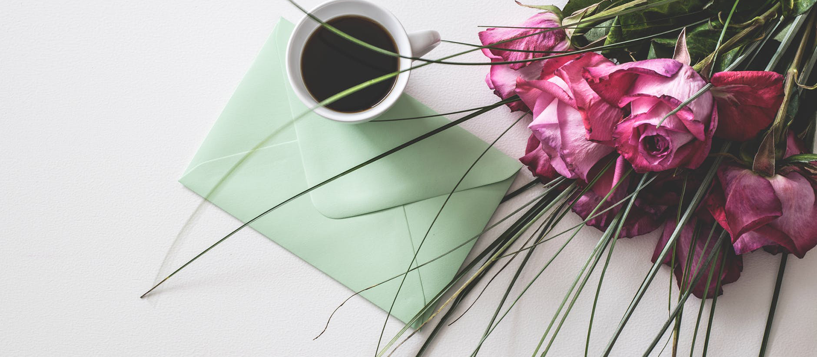 flowers and card on the table with a cup of coffee