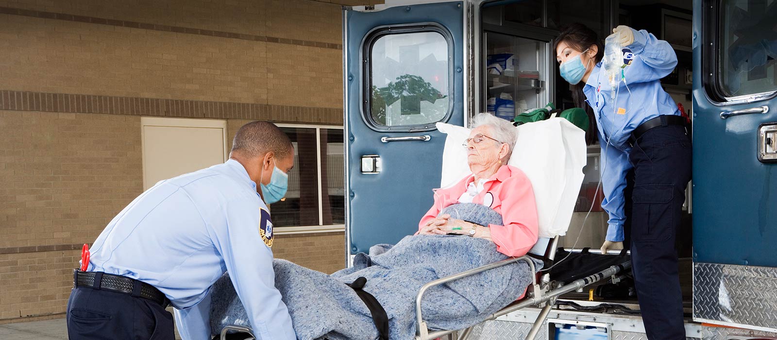 Senior patient entering ambulance by medics