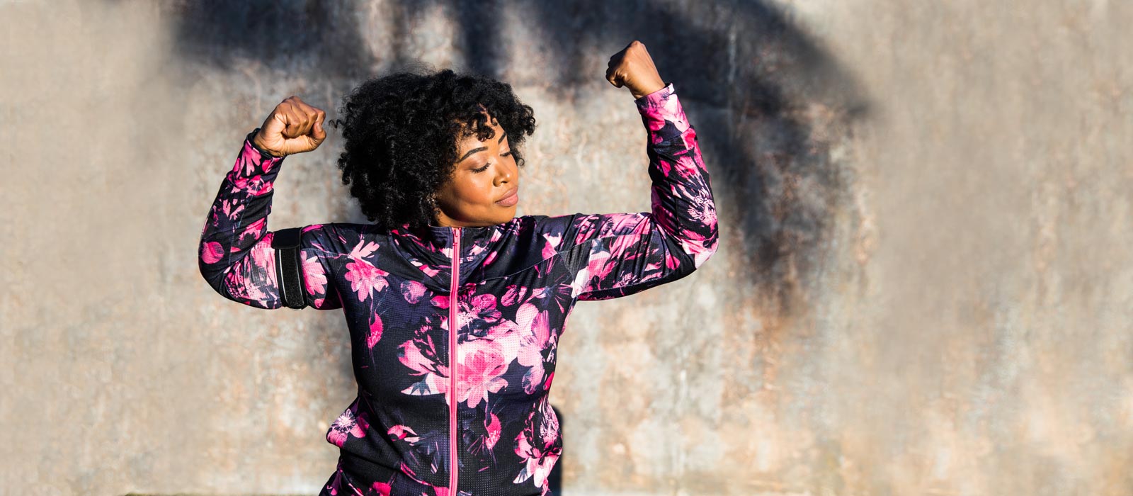 Diverse woman flexing arm muscles