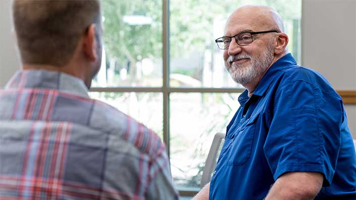 man listening in group therapy session