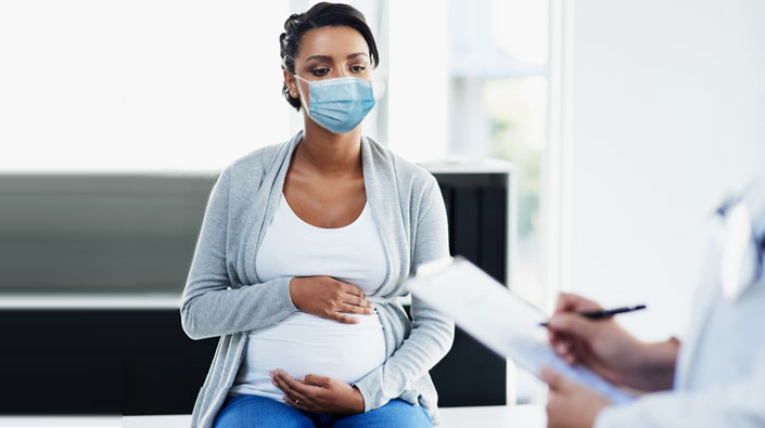 anxious pregnant woman speaking with healthcare provider