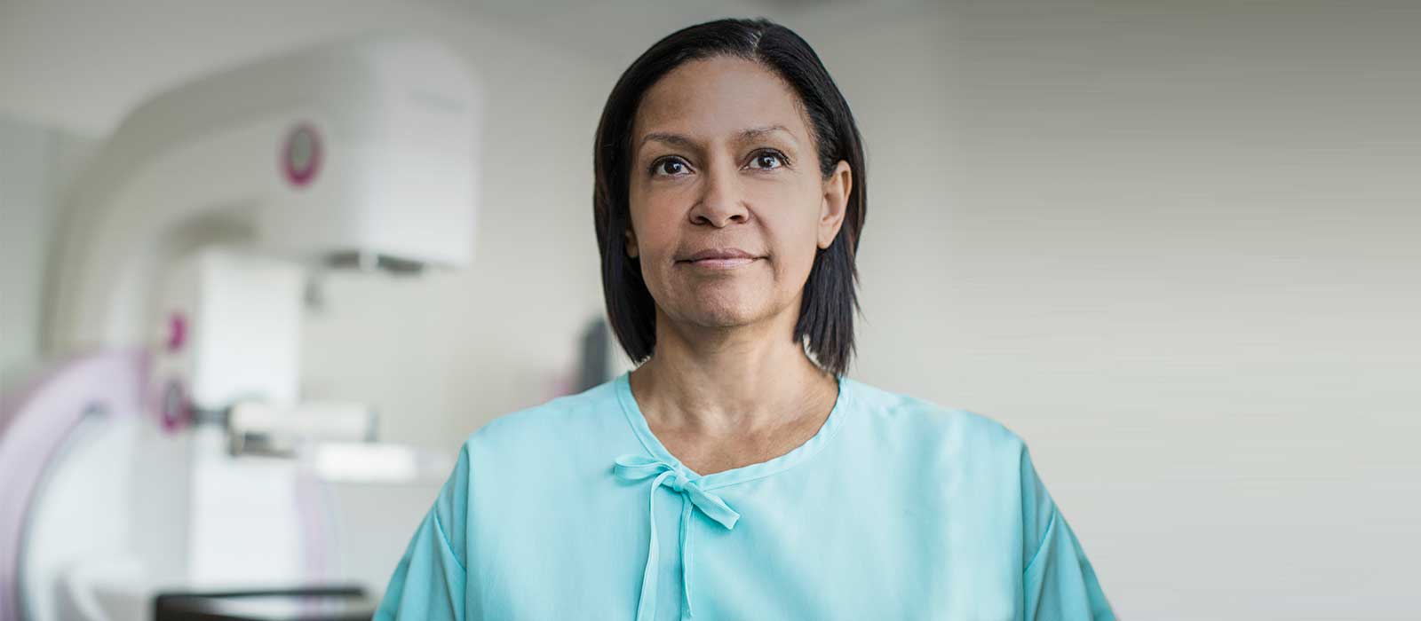 woman standing in front of mammography machine