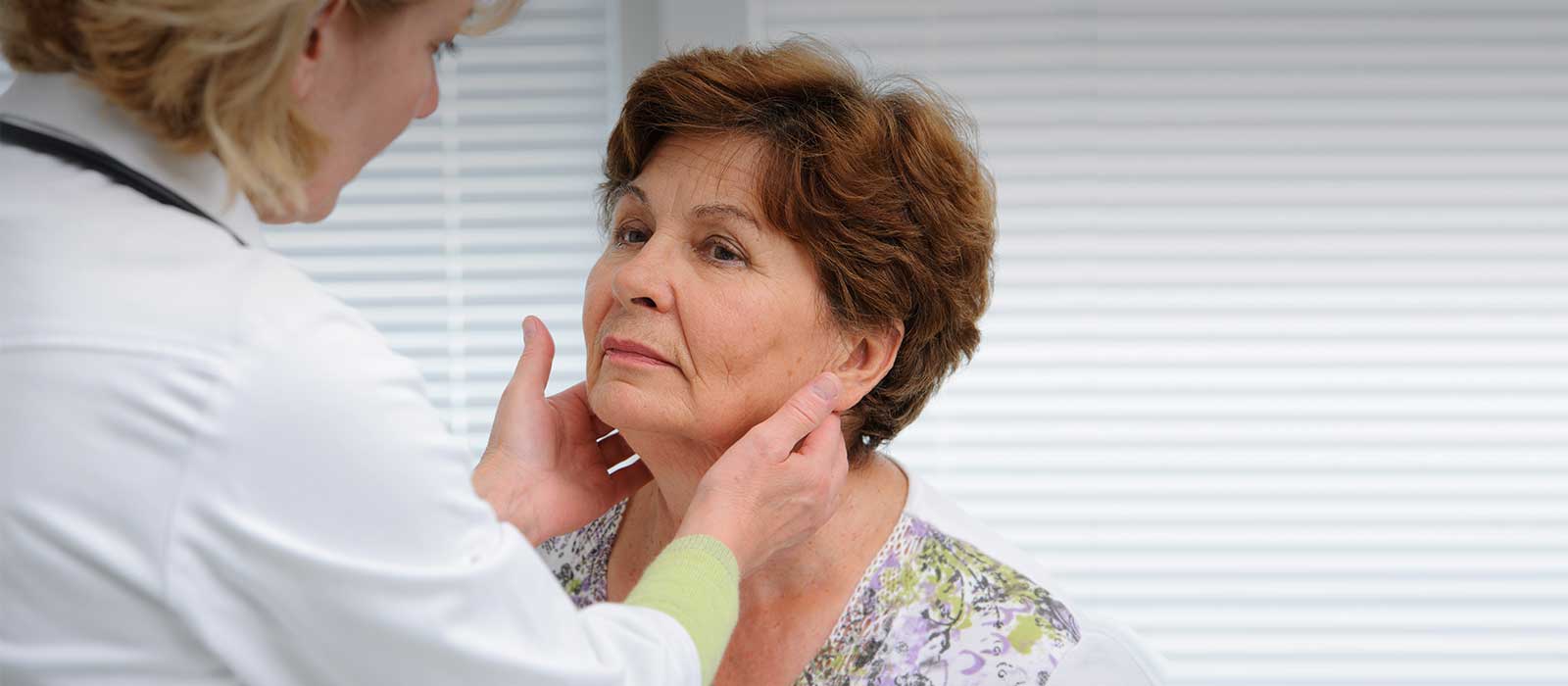 doctor diagnosing woman with head and neck condition