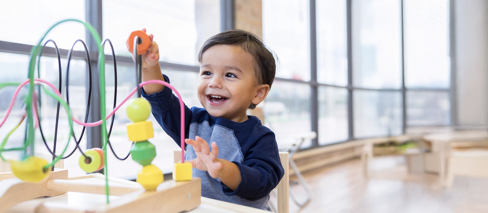 young boy playing with wooden puzzle