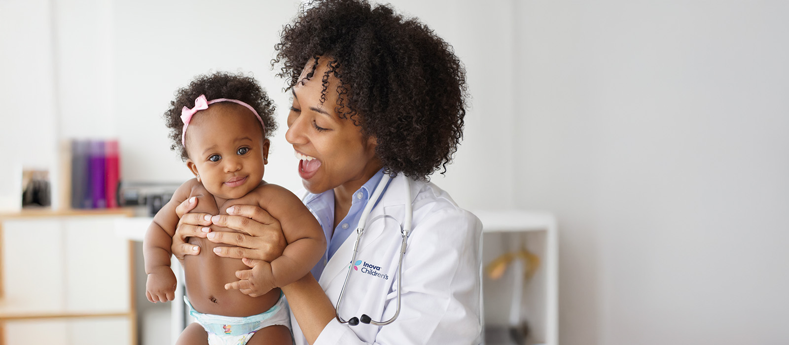 diverse baby held by female doctor
