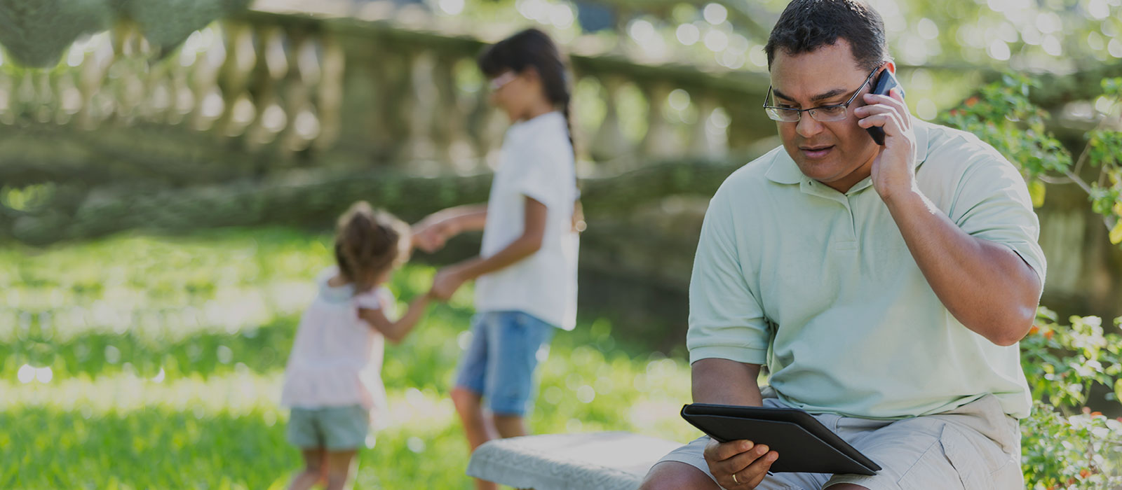 man on cell phone with children