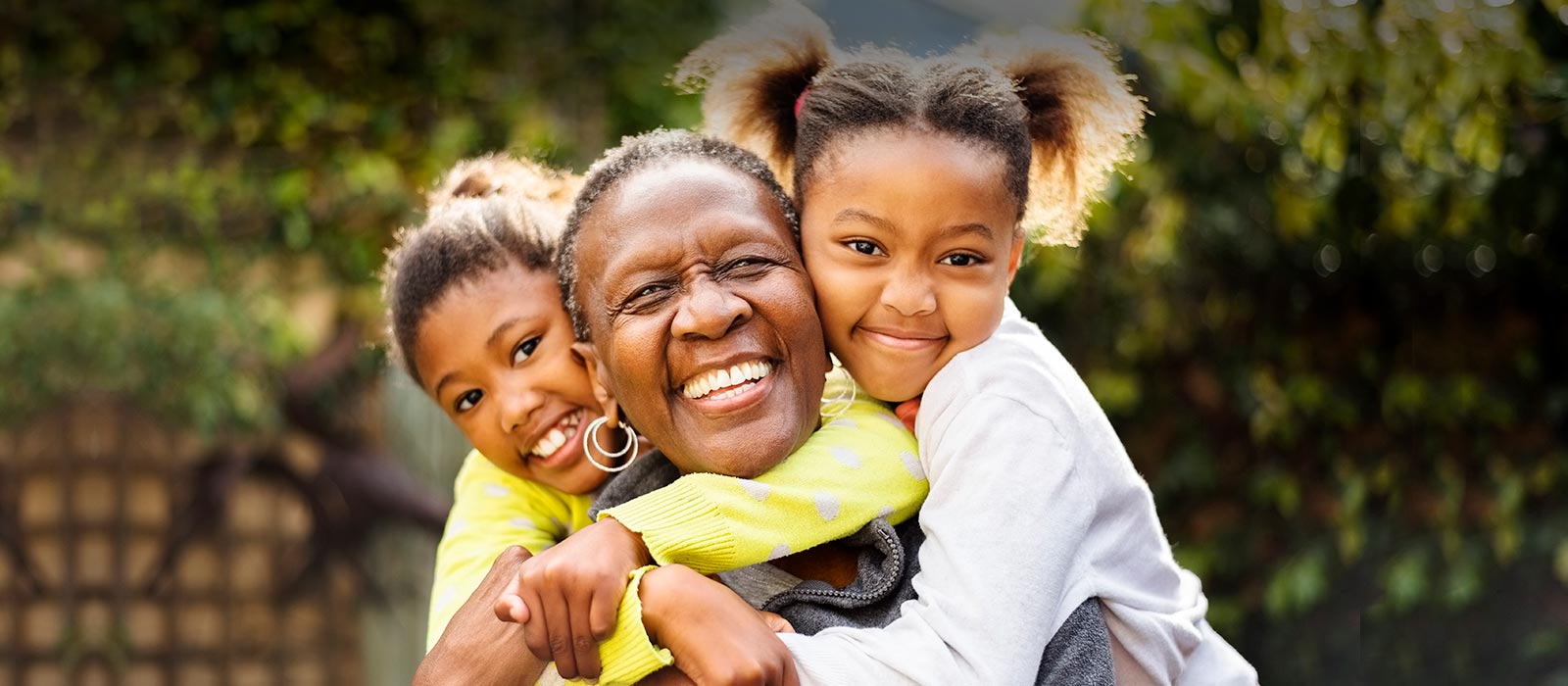 Diverse grandmother hugging with granddaughters