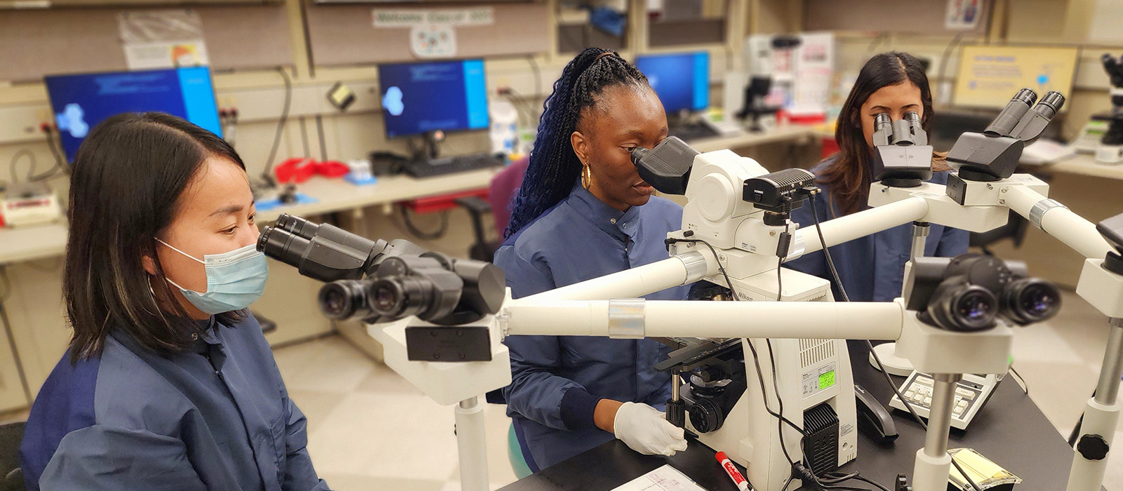 Lab team viewing microscope
