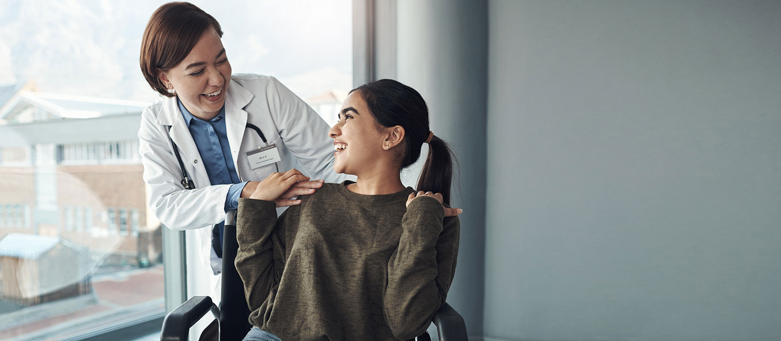 Female doctor and young patient in wheelchair 