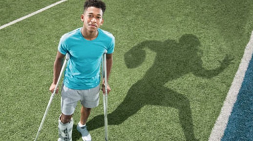 Young athlete on crutches on football field