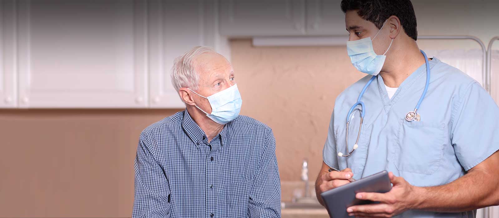 a young doctor reviewing information on a tablet with an older patient.