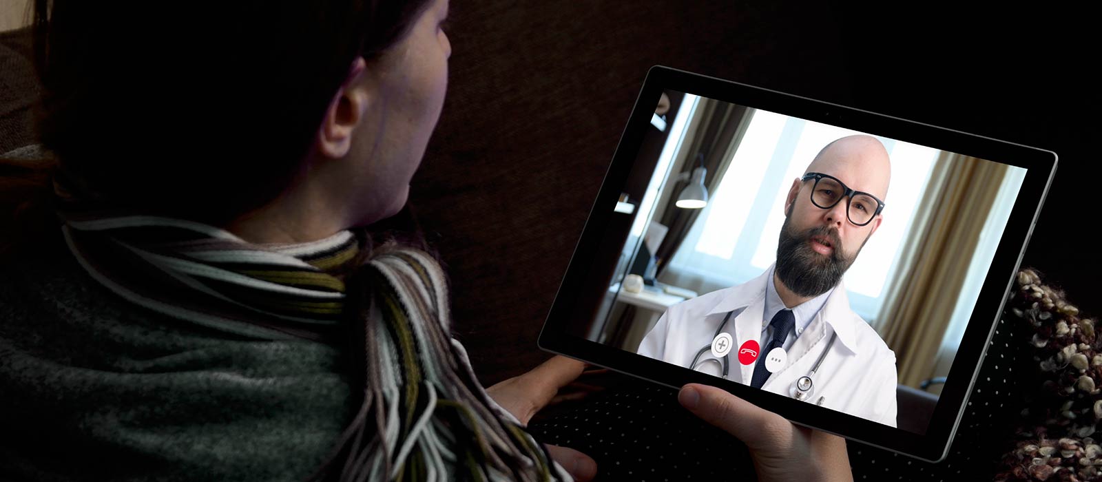 Female patient talking with doctor on laptop screen 