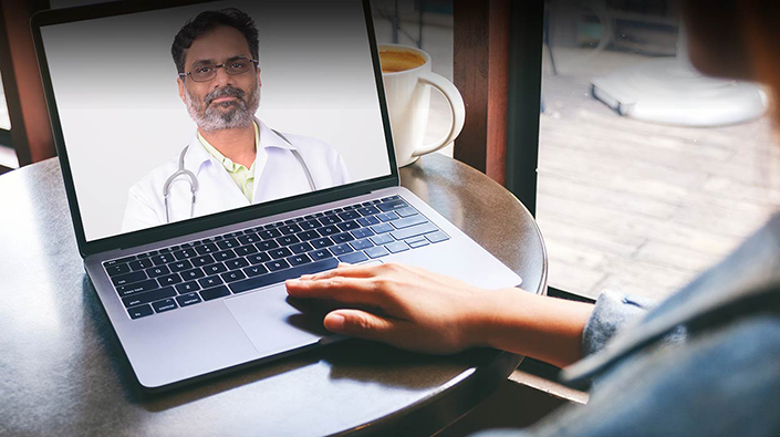 Person having a video visit with a doctor on a laptop screen