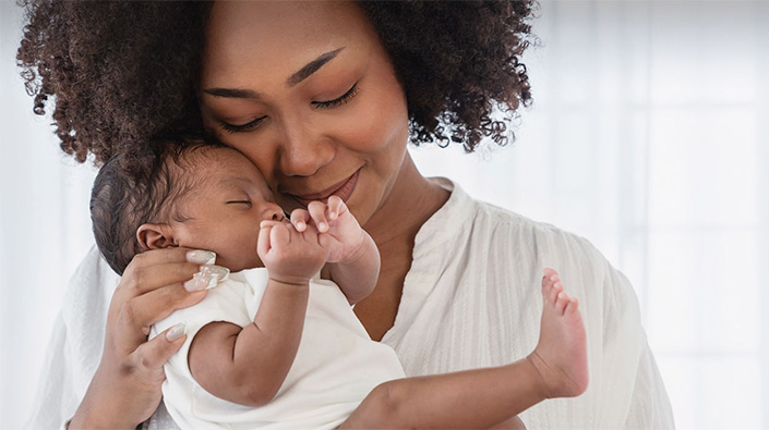 Diverse holding newborn 