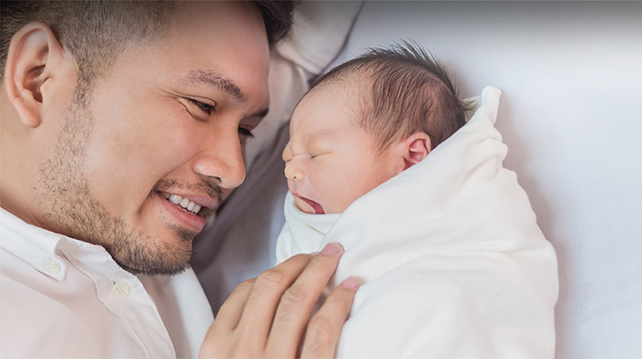 New dad smiling at newborn