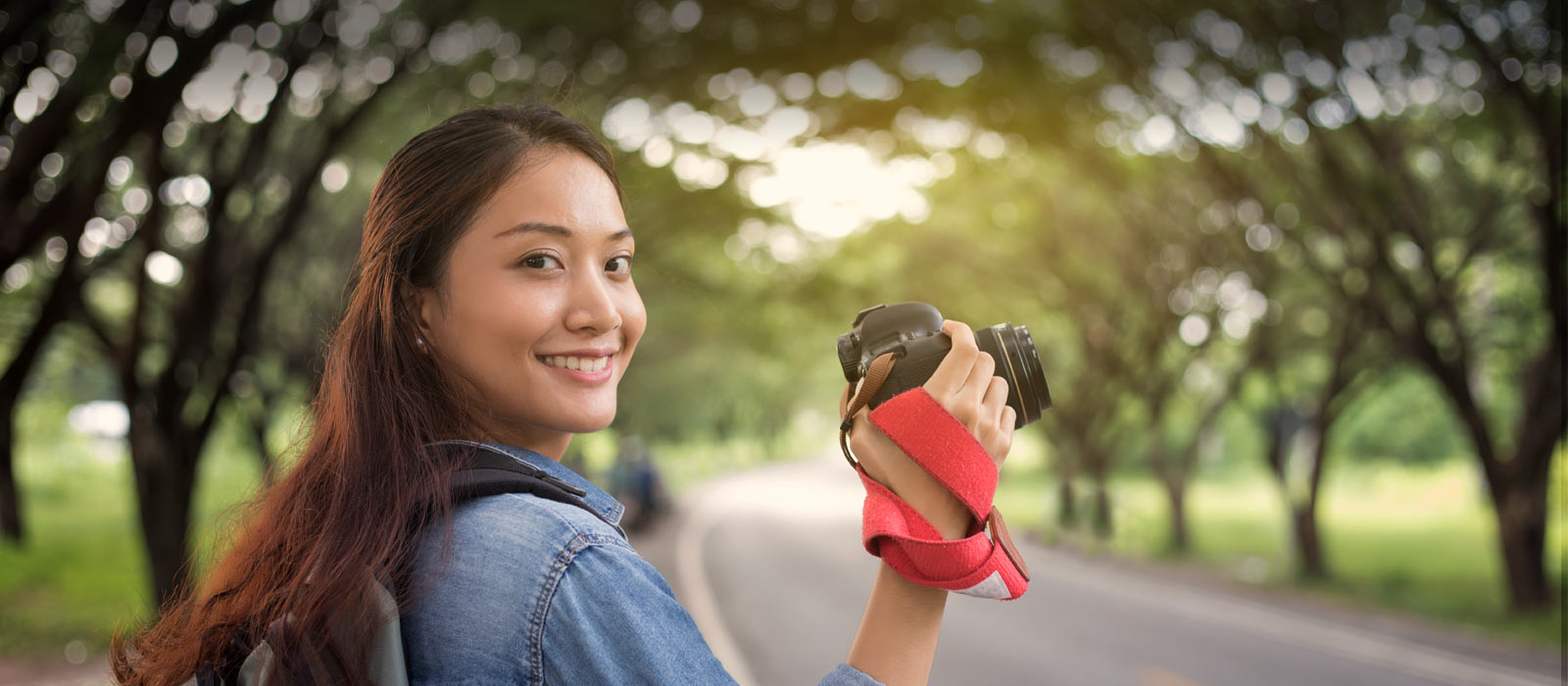 Young Asian woman taking photos outdoors