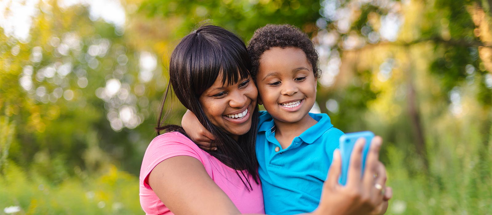 Afro-American mom and son taking selfie photo outdoors