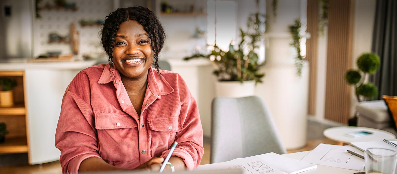 Friendly woman using laptop in kitchen