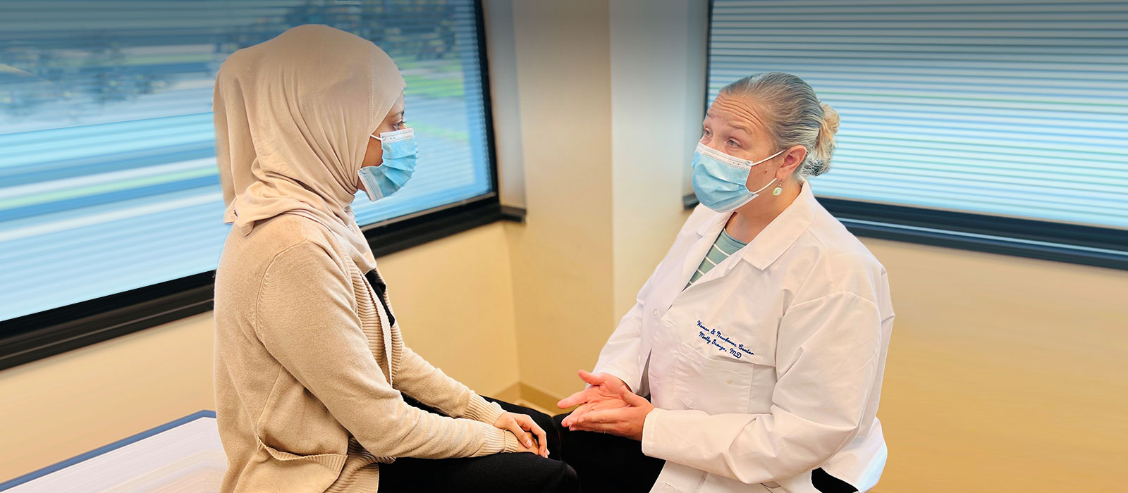 Masked Female patient and doctor conversation