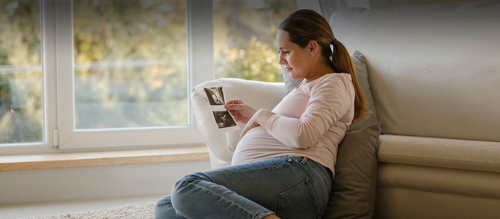 Pregnant woman holding sonogram image