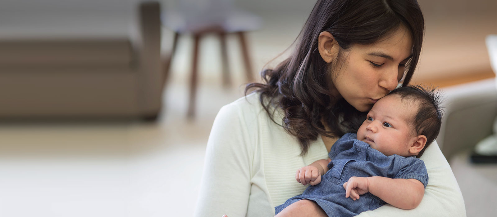 New mom kissing her infant.