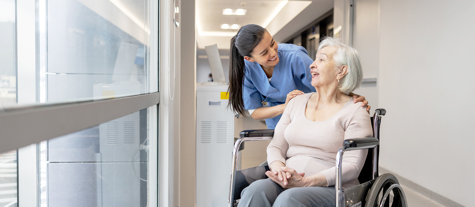 Smiling nurse and mature female patient