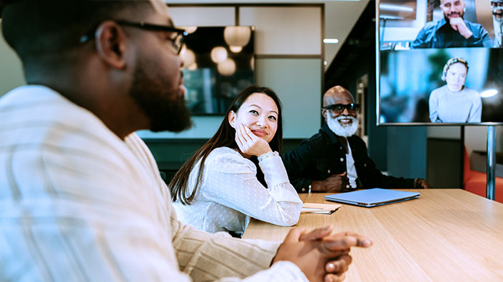 Diverse people meeting in person and video conference