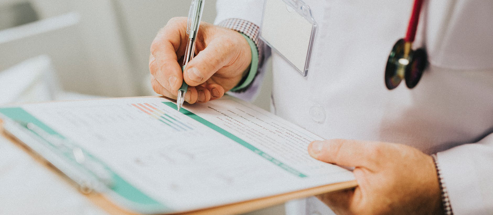 doctor writing notes on clipboard