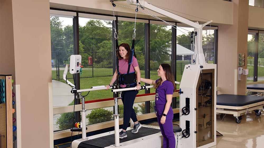 patient walking on an assisted treadmill