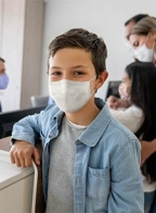 Masked young boy with family 
