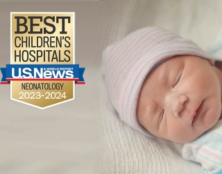 Sleeping infant with US News Report badge.