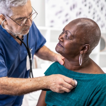 Healthcare worker examining senior female patient