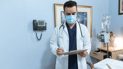 provider reviewing a chart in hospital room