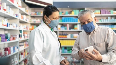 female pharmacist explaining a medicine to a customer