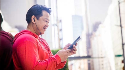 Diverse man using smartphone with headphones