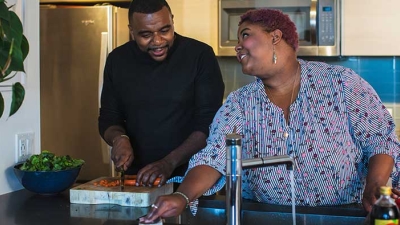 African American couple preparing healthy dinner in kitchen