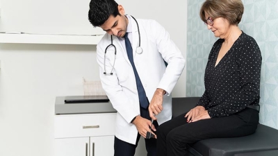Doctor examining mature female patient