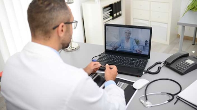 Doctor consulting patient via video visit. 