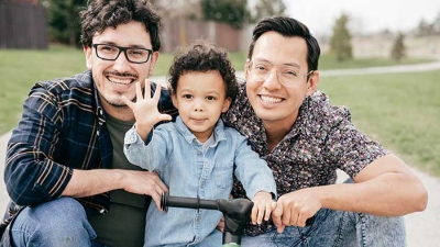 Same sex couple with child on scooter