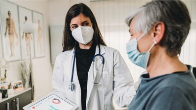 Masked doctor and middle aged patient