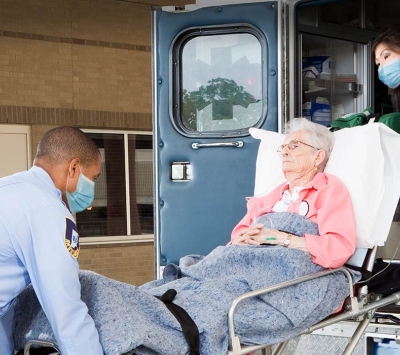 Senior patient entering ambulance by medics