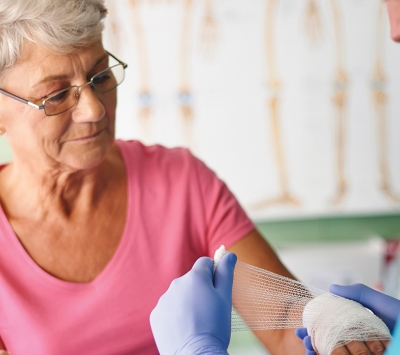 older woman receiving wound treatment