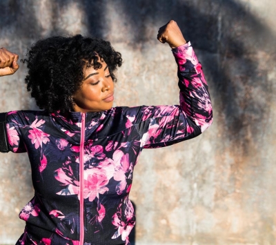 Diverse woman flexing arm muscles