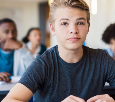adolescent boy sitting in classroom