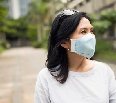 Middle aged Asian woman wearing protective mask.