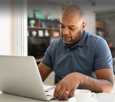 Middle aged diverse man using laptop 