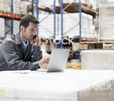 man in warehouse on laptop