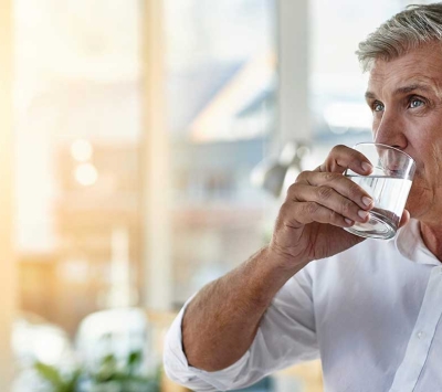 Mature man drinking water.