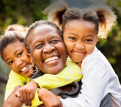 Diverse grandmother hugging with granddaughters