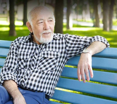 Mature man relaxing on park bench